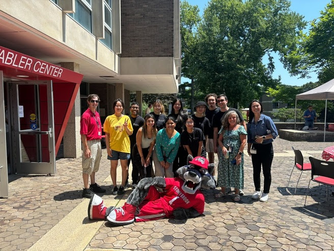 Student staff and employees standing in front of the Tabler Center with Wolfie