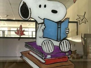 snoopy reading a book with leaves falling around him