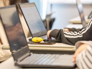 Students using their laptops in a classroom.