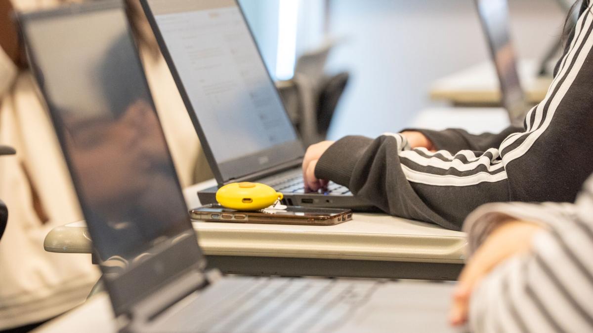 Students using their laptops in a classroom.