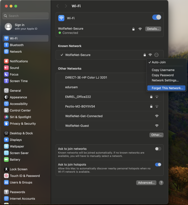 A screenshot of the macOS Wi-Fi settings window. The system is connected to 'WolfieNet-Secure', and an options dropdown menu is open next to it showing choices like 'Auto-Join' and 'Forget This Network'.
